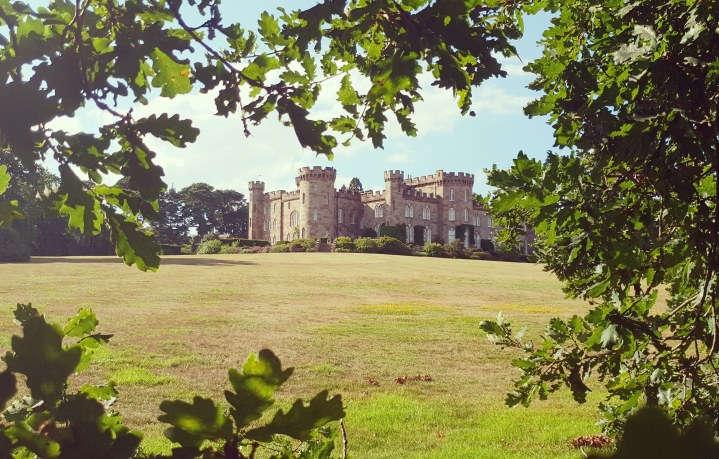 Cholmondeley Castle. Castle through trees. 4 freckled faces. Castles in Cheshire.