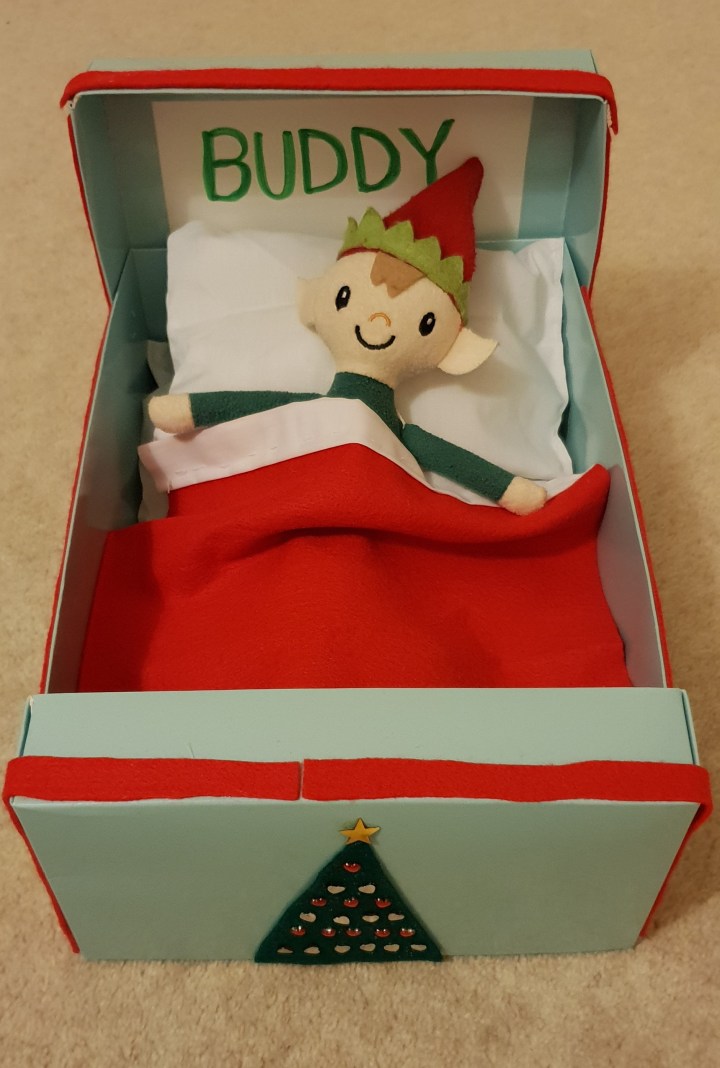 A teddy christmas elf with a red hat in his bed. Buddy the Elf. Elf on the shelf. 4 Freckled Faces